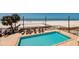 Stunning pool overlooking the beach with lounge chairs and tropical landscaping at 13600 Gulf Blvd # 700A, St Petersburg, FL 33708
