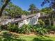 The exterior of this house is surrounded by lush plants and mature trees at 1602 Cottagewood Dr, Brandon, FL 33510
