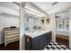 Bathroom with double sinks, large vanity mirror, checkered floors, and access to walk-in closet at 1610 Navigator Ln, Tarpon Springs, FL 34689