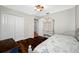 Cozy bedroom boasts wood flooring, a ceiling fan, painted dresser and daybed next to closet at 1610 Navigator Ln, Tarpon Springs, FL 34689