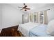 Bright bedroom with hardwood floors, ceiling fan, and sliding glass doors to a patio at 1610 Navigator Ln, Tarpon Springs, FL 34689