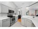 Well-lit kitchen with updated appliances, bright white countertops, and gray cabinetry at 1610 Navigator Ln, Tarpon Springs, FL 34689