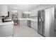 Modern kitchen featuring white cabinets, stainless steel appliances, stylish floors, and ample counter space at 1610 Navigator Ln, Tarpon Springs, FL 34689