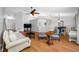 Spacious living room with hardwood floors, a ceiling fan, and an open view to the dining and kitchen areas at 1610 Navigator Ln, Tarpon Springs, FL 34689