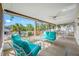 The screened-in patio has bright blue patio furniture with a view of the community pool at 1610 Navigator Ln, Tarpon Springs, FL 34689
