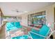 Large screened-in patio with blue furniture overlooking the community pool, perfect for relaxing at 1610 Navigator Ln, Tarpon Springs, FL 34689