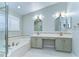 Bright bathroom featuring a double vanity, bathtub, and shower with a glass door at 1632 Gray Bark Dr, Oldsmar, FL 34677