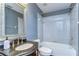Bathroom features a vanity with a granite countertop, a large mirror, and a shower/tub combo at 1632 Gray Bark Dr, Oldsmar, FL 34677