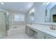 Bright bathroom featuring double sinks, bathtub, and separate shower at 1632 Gray Bark Dr, Oldsmar, FL 34677