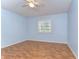 Airy bedroom featuring vinyl plank floors, a ceiling fan, and a window with plantation shutters at 1632 Gray Bark Dr, Oldsmar, FL 34677