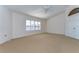 Spacious bedroom featuring carpet flooring, a ceiling fan, and plantation shutters at 1632 Gray Bark Dr, Oldsmar, FL 34677