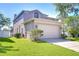 Exterior shot of home with two car garage, lush lawn, and a fenced in backyard at 1632 Gray Bark Dr, Oldsmar, FL 34677