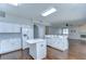 Modern kitchen with white cabinets, island, stainless appliances, and an open view to the living area at 1632 Gray Bark Dr, Oldsmar, FL 34677