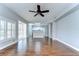 Bright living room with wood floors, ceiling fan, and an open view of the kitchen at 1632 Gray Bark Dr, Oldsmar, FL 34677