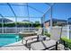 Screened-in pool area with lounge chairs and inground hot tub at 1632 Gray Bark Dr, Oldsmar, FL 34677