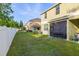 Lush green backyard with a white fence, mature trees, and a screened-in patio, offering privacy at 20224 Pond Apple Ln, Tampa, FL 33647