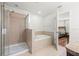 Bright bathroom featuring a glass enclosed shower and separate soaking tub next to the primary bedroom at 20224 Pond Apple Ln, Tampa, FL 33647