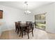 Bright dining area with a dark wood table, chandelier lighting, and sliding glass doors at 20224 Pond Apple Ln, Tampa, FL 33647