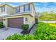 Well-maintained townhome boasts a two-car garage, complemented by verdant landscaping, and a pristine walkway at 20224 Pond Apple Ln, Tampa, FL 33647