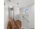 An upstairs hallway with hardwood floors, white walls, and a window that brings in natural light at 20224 Pond Apple Ln, Tampa, FL 33647