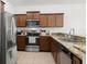 A well-lit kitchen features stainless steel appliances, granite countertops, and wood cabinetry at 20224 Pond Apple Ln, Tampa, FL 33647