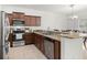 A kitchen boasts stainless steel appliances, granite countertops, wood cabinetry, and tile floors at 20224 Pond Apple Ln, Tampa, FL 33647