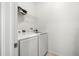 A compact laundry room with a wire shelf features a front-loading washer and dryer at 20224 Pond Apple Ln, Tampa, FL 33647
