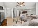 Open-concept living room with neutral tile flooring, gray sectional sofa, staircase and abundant natural light at 20224 Pond Apple Ln, Tampa, FL 33647