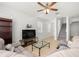 Cozy living room featuring a sectional sofa, neutral tile, a ceiling fan, and ample natural light at 20224 Pond Apple Ln, Tampa, FL 33647