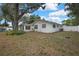 A spacious backyard with a well-maintained lawn and a large tree providing ample shade at 215 Deer Park Ave, Temple Terrace, FL 33617