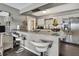 Kitchen with a bar and seating, featuring stainless steel appliances and a refrigerator with an ice maker at 215 Deer Park Ave, Temple Terrace, FL 33617