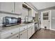 Charming kitchen features stainless steel appliances, granite countertops, and white cabinetry at 215 Deer Park Ave, Temple Terrace, FL 33617