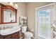 Cozy bathroom featuring a window, decorative mirror and cabinet sink at 2800 Flagler Ct, Trinity, FL 34655