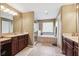 Well-lit bathroom features double sink vanity, large soaking tub, and walk-in shower for a spa-like experience at 2800 Flagler Ct, Trinity, FL 34655