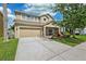 Lovely two-story home featuring a green lawn, an attached garage and a landscaped garden bed at 2800 Flagler Ct, Trinity, FL 34655
