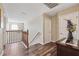Well-lit hallway with wood floors, white doors, decorative flowers and wooden banister at 2800 Flagler Ct, Trinity, FL 34655
