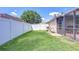 Fenced backyard has grass and a screened-in porch area at 2927 Hickory Grove Dr, Valrico, FL 33596
