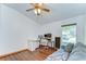 Office space with wood floors, desk, gray sofa, ceiling fan, and natural light from a window at 2927 Hickory Grove Dr, Valrico, FL 33596
