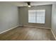 A spacious bedroom features hard surface floors, a ceiling fan and a large window at 3025 Bonaventure Cir # 103, Palm Harbor, FL 34684