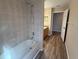Bathroom featuring a tiled shower-over-tub combination and wood-look flooring at 3355 Abeline Rd, Spring Hill, FL 34608