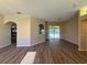 Open living space featuring a view of the kitchen, sliding glass doors to the backyard and new modern flooring at 3355 Abeline Rd, Spring Hill, FL 34608