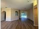 An open living space with wood floors leading to a screened lanai with backyard views at 3355 Abeline Rd, Spring Hill, FL 34608