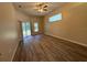 Large living room featuring wood-look laminate flooring and sliding glass doors at 3355 Abeline Rd, Spring Hill, FL 34608