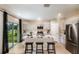 Modern kitchen featuring stainless steel appliances, an island with bar seating, and sliding glass doors at 37213 Sagemoor Dr, Zephyrhills, FL 33541