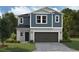 Two-story home featuring blue siding, a gray stone foundation, and a two-car garage at 37244 Sagemoor Dr, Zephyrhills, FL 33541