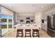 Bright kitchen featuring gray cabinets, a center island with bar stools, and stainless steel appliances at 37252 Sagemoor Dr, Zephyrhills, FL 33541