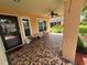 The front porch features vibrant, patterned tile flooring and a ceiling fan for added comfort at 4814 Grist Mill Cir, New Port Richey, FL 34655