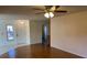 Inviting living room showcasing hardwood floors, a ceiling fan, and a bright front door at 4814 Grist Mill Cir, New Port Richey, FL 34655