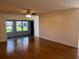 The bright living room features wood floors, a ceiling fan, and a sunroom with scenic views at 4814 Grist Mill Cir, New Port Richey, FL 34655