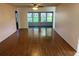 Spacious living room featuring hardwood floors, a ceiling fan, and an attached sunroom with ample light at 4814 Grist Mill Cir, New Port Richey, FL 34655